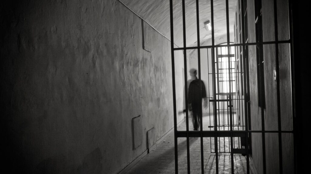 person walking through jail cell