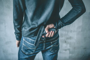 New Jersey man facing firearms charges hiding a gun behind his back – consult a firearms charges attorney