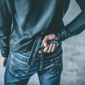 New Jersey man facing firearms charges hiding a gun behind his back – consult a firearms charges attorney